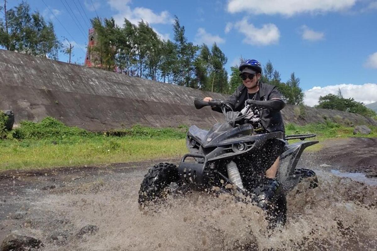 a man riding a fourwheeler through a mud loggedescription