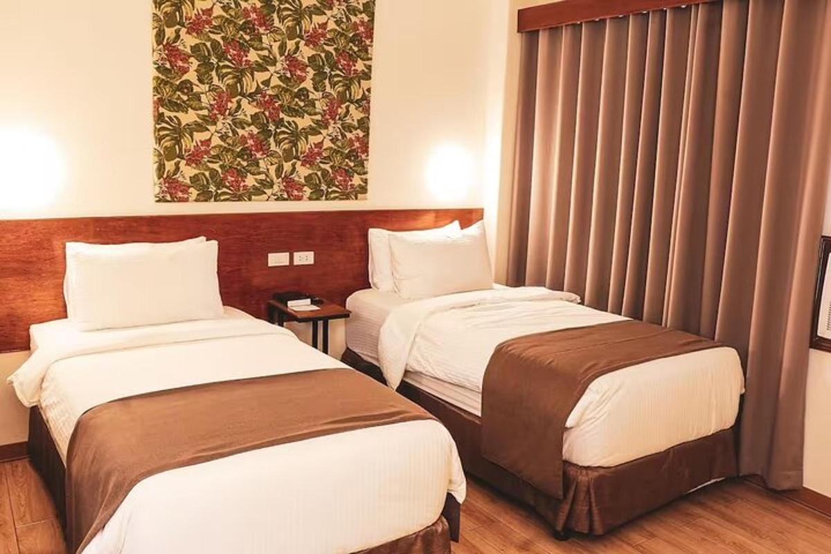 a hotel room with two beds and a painting on the wall