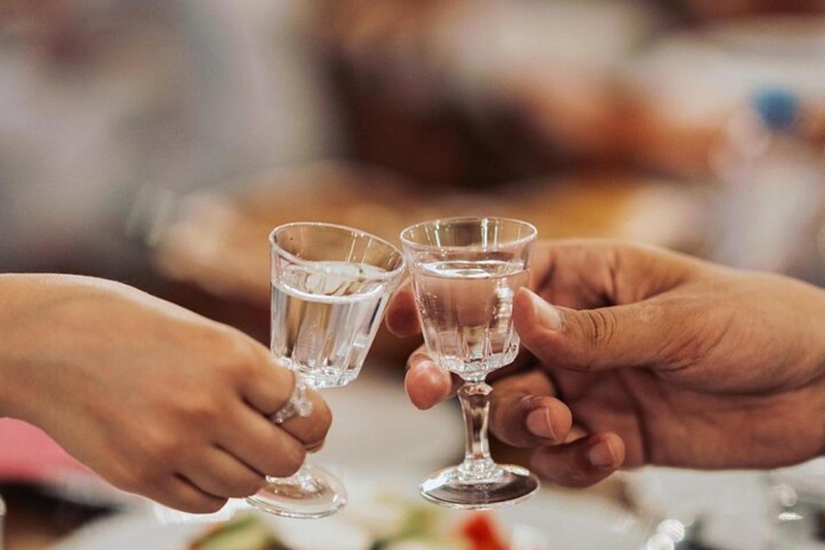 due persone che tengono in mano dei bicchieri d'acqua su un tavolo