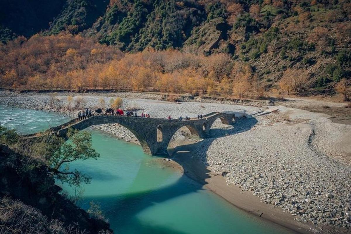 a group of people crossing a bridge over a river