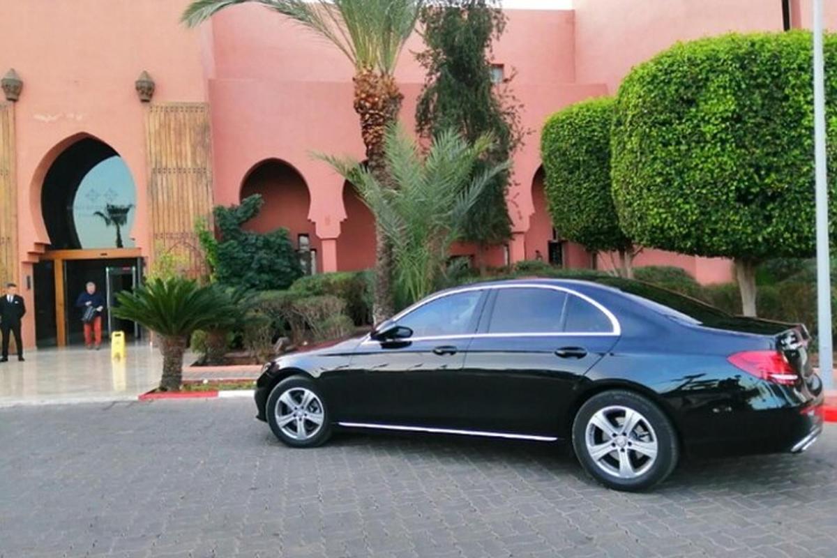 un'auto nera parcheggiata davanti a un edificio rosa