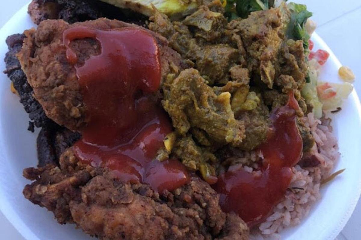 a plate of food with meat and ketchup and rice