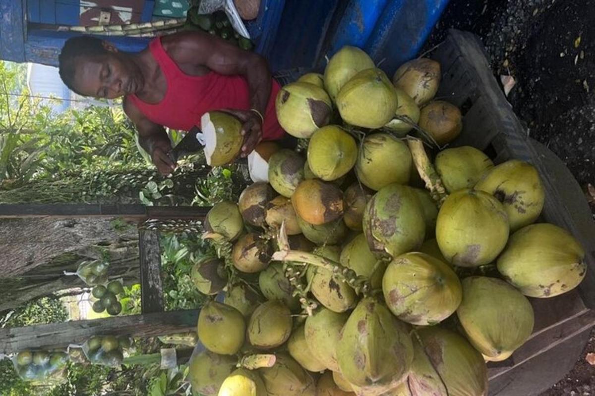un uomo è in piedi accanto a una grande pila di frutta