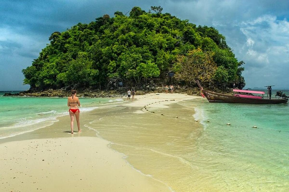 eine Frau steht an einem Strand vor einer Insel