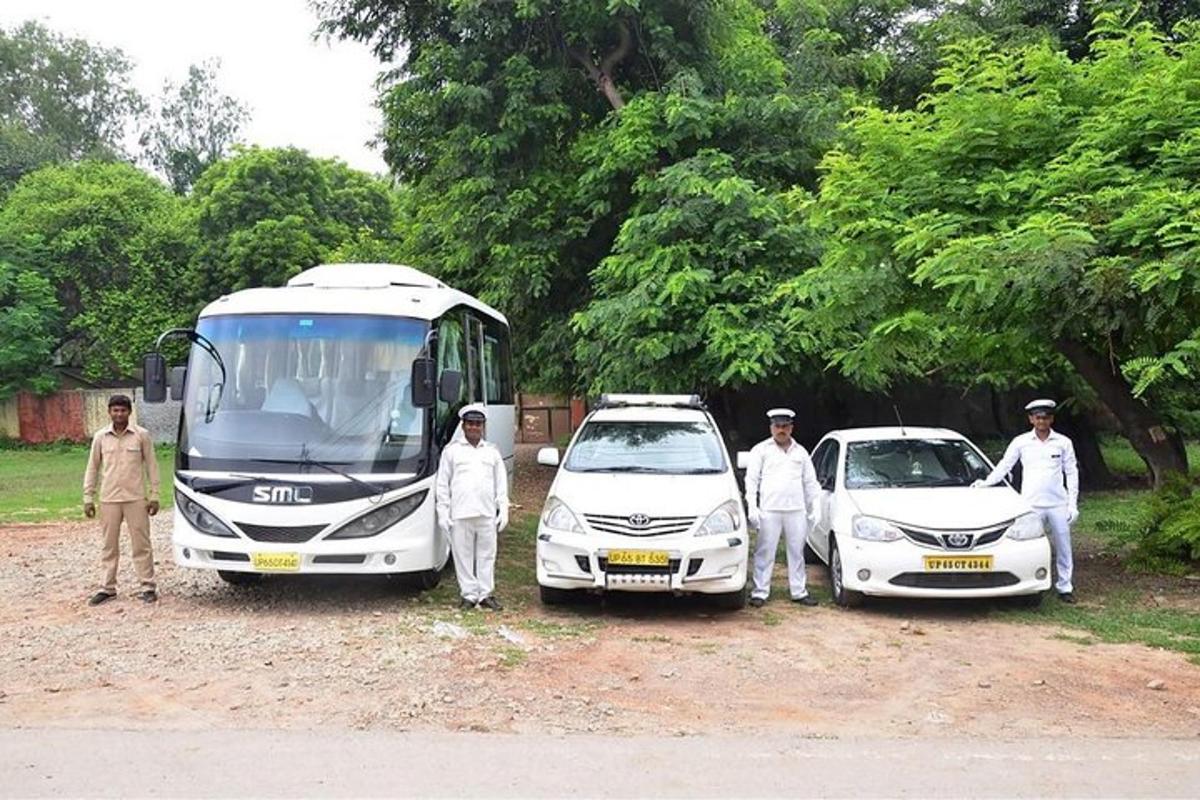 un grup de persones al costat d'un autobús i cotxes