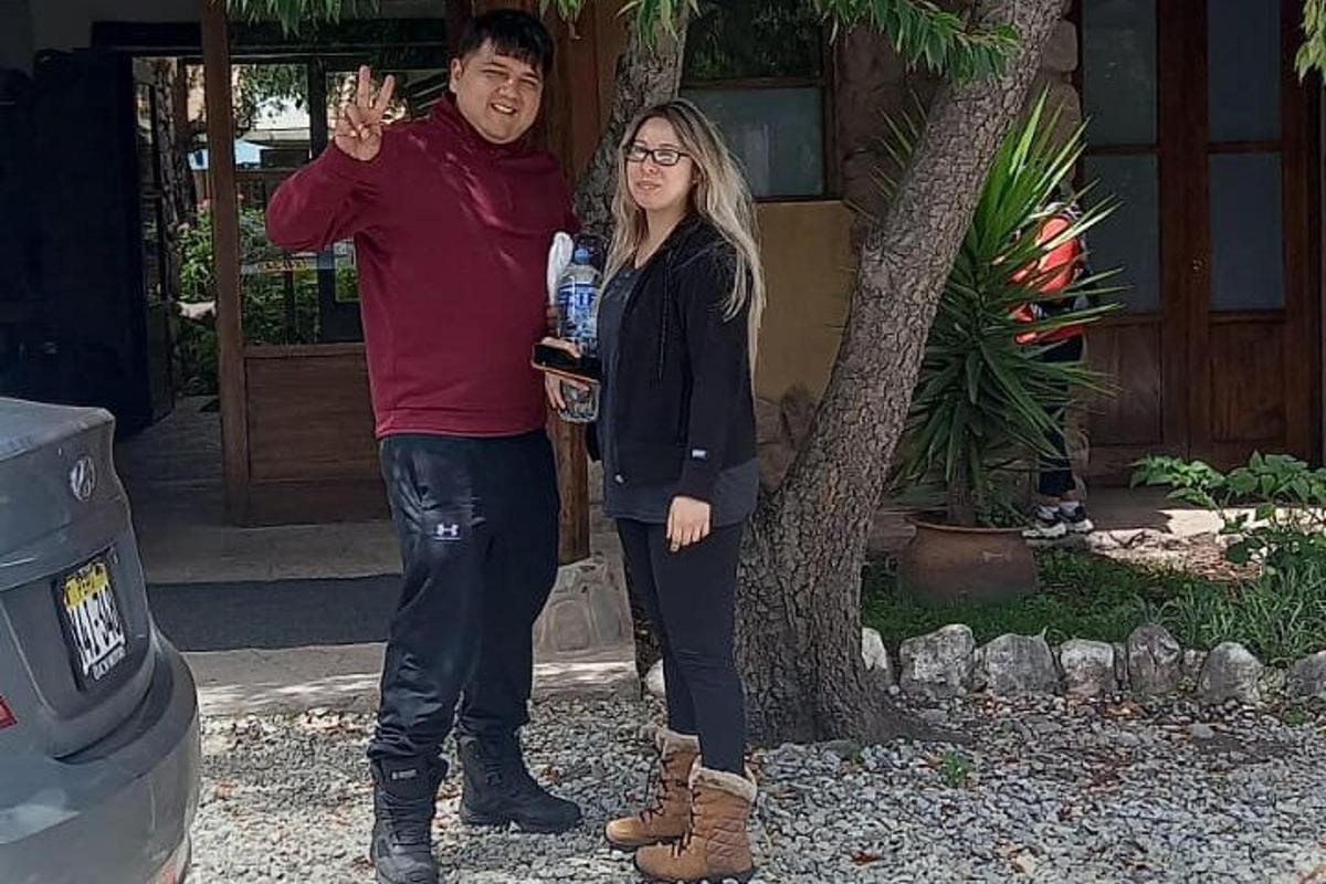 Un hombre y una mujer de pie junto a un árbol.