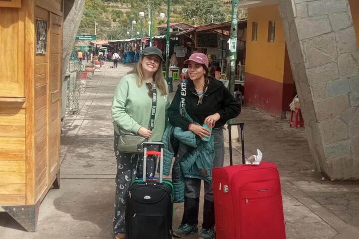 Dos mujeres paradas una al lado de la otra con equipaje.