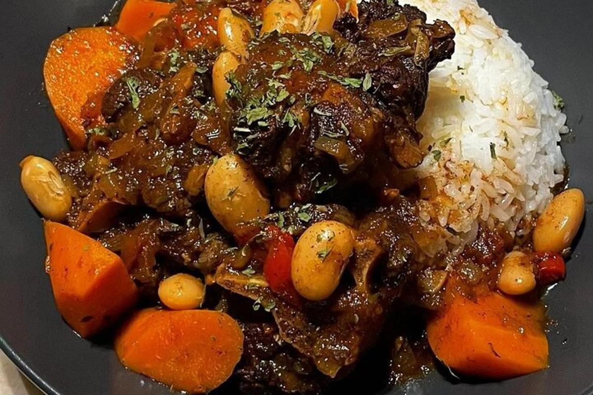 een bord eten met vlees, wortelen en rijst