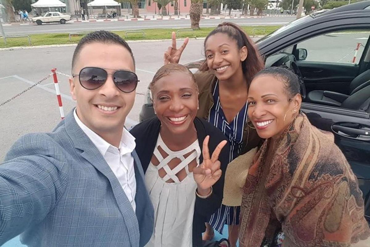 um grupo de pessoas em pé ao lado de um carro