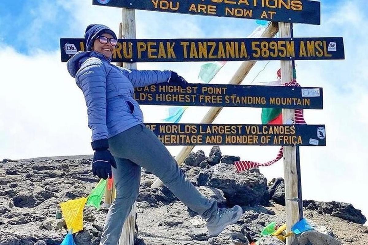 žena stojící vedle cedule na hoře