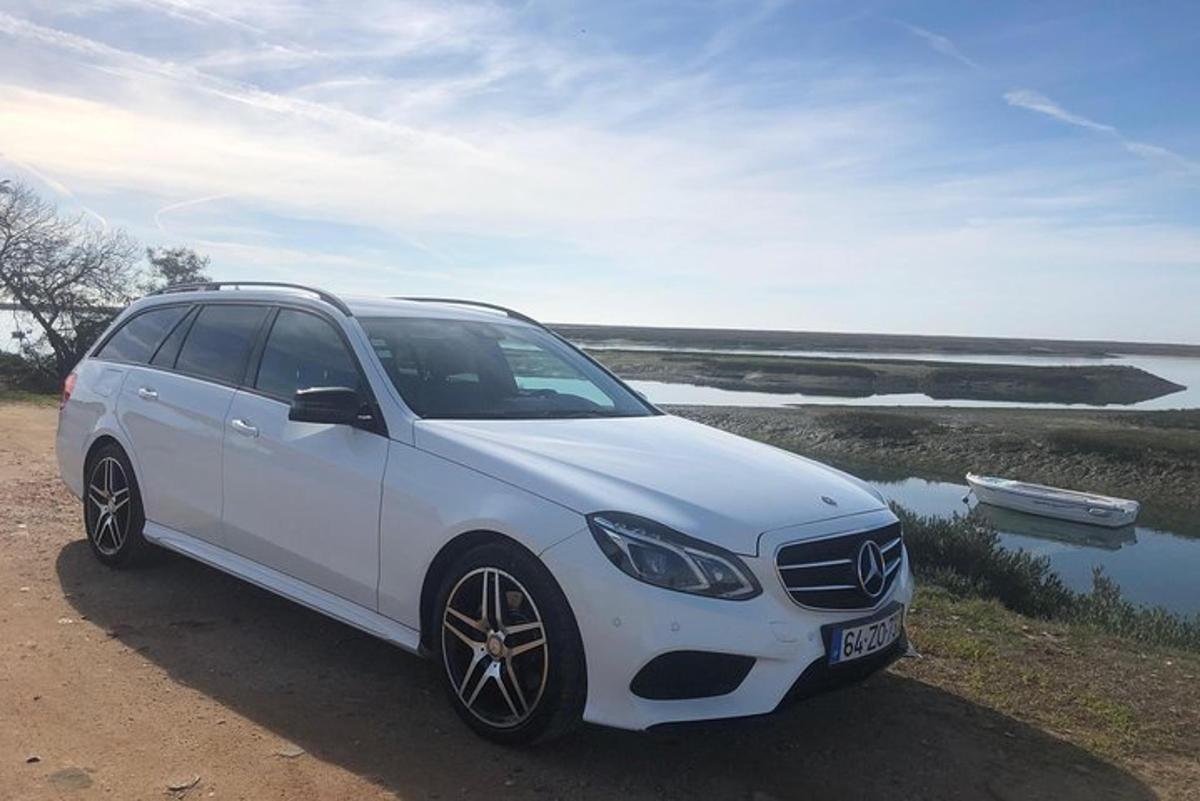 Un coche blanco estacionado junto a un cuerpo de agua