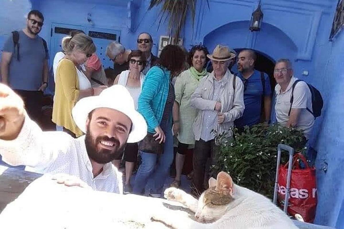 grupp inimesi, kes seisavad mehe ja kassi ümber