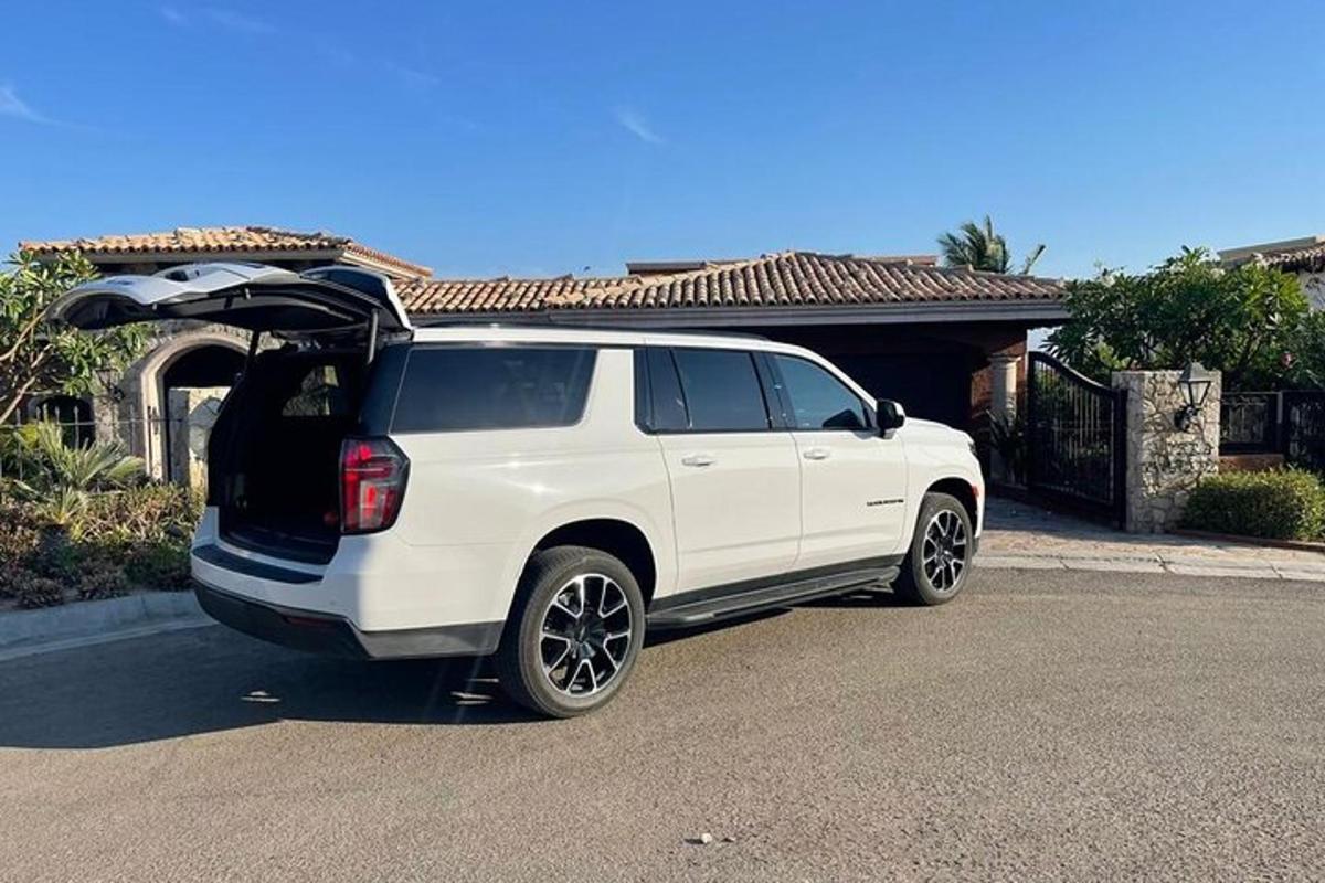 a white suv parked in front of a house