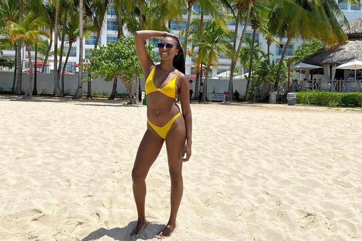 o femeie într-un bikini galben stând pe o plajă