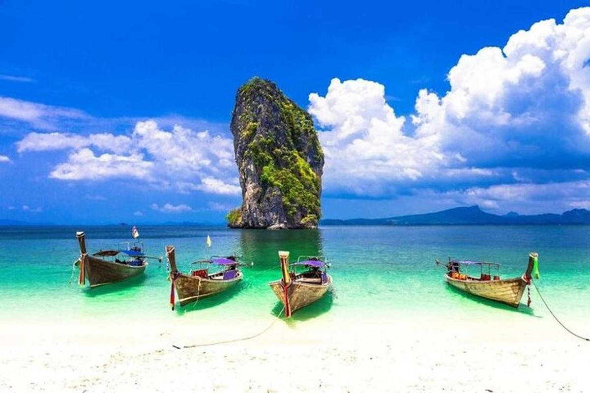 tiga perahu di pantai dengan batu di air