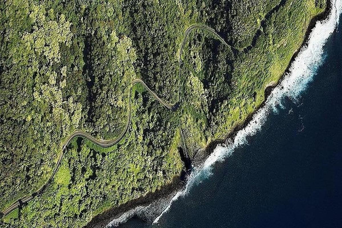 Una vista aérea de una carretera en una montaña junto al océano.