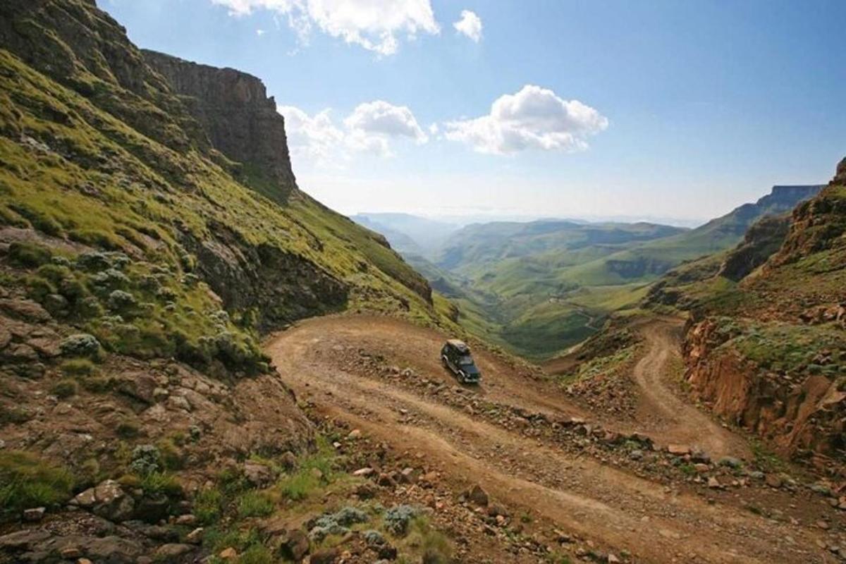 un'auto che percorre una strada sterrata in un canyon