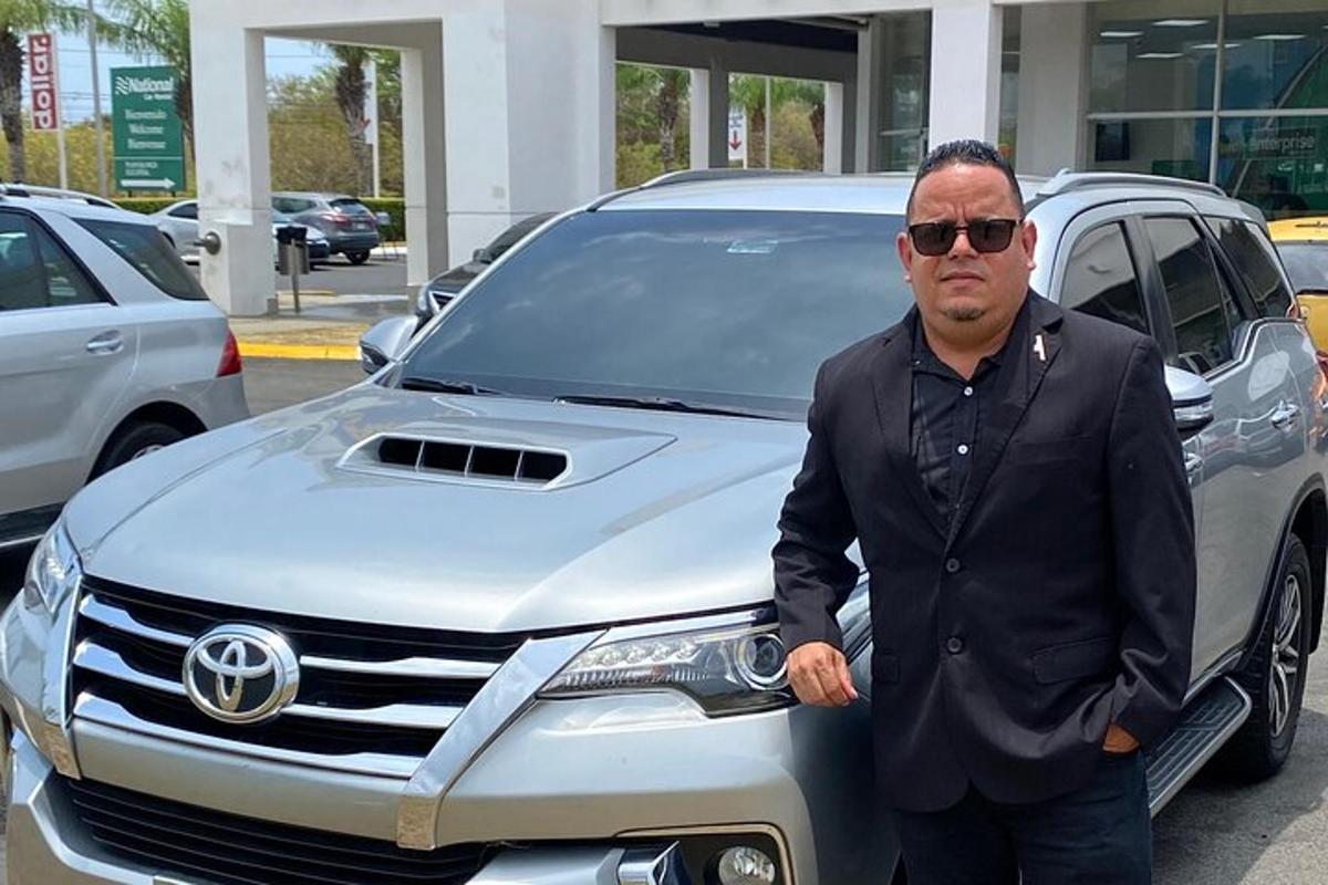 a man standing in front of a silver car