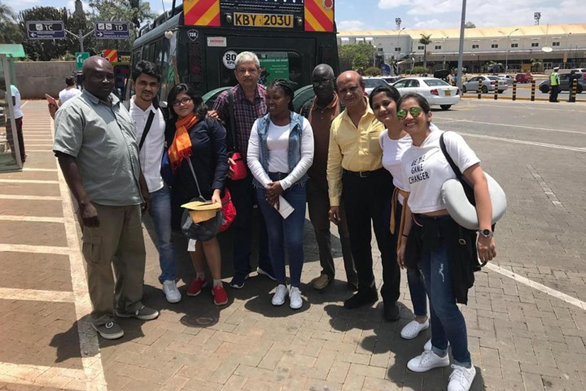un grup de persones dretes davant d'un autobús