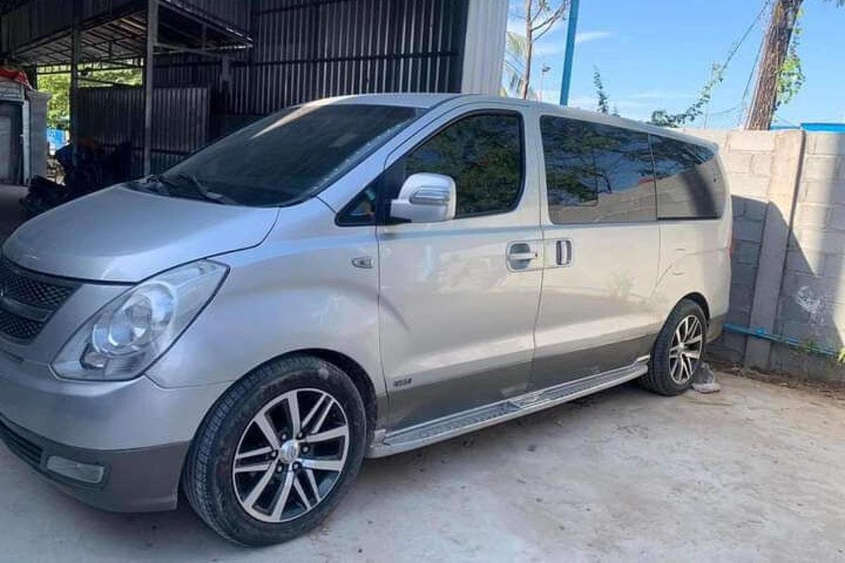 a silver minivan parked in front of a building
