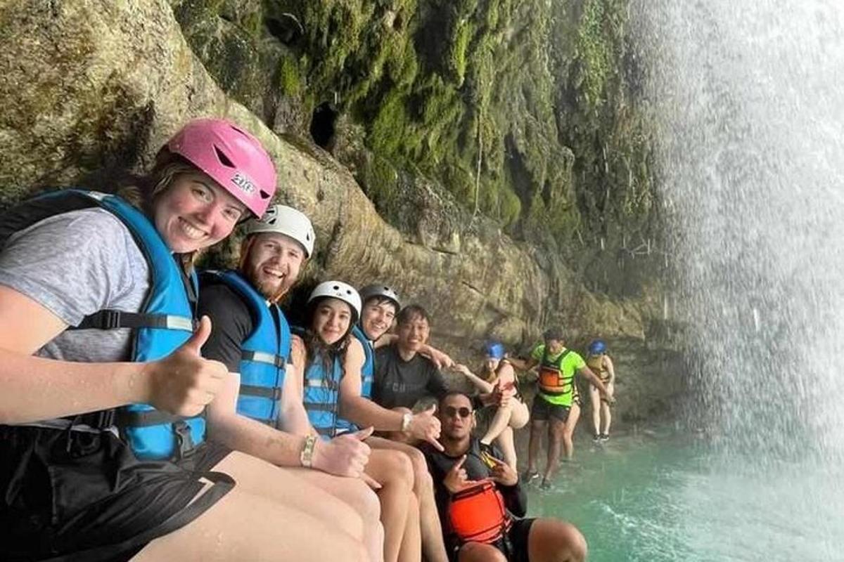 eine Gruppe von Menschen auf einem Floß vor einem Wasserfall