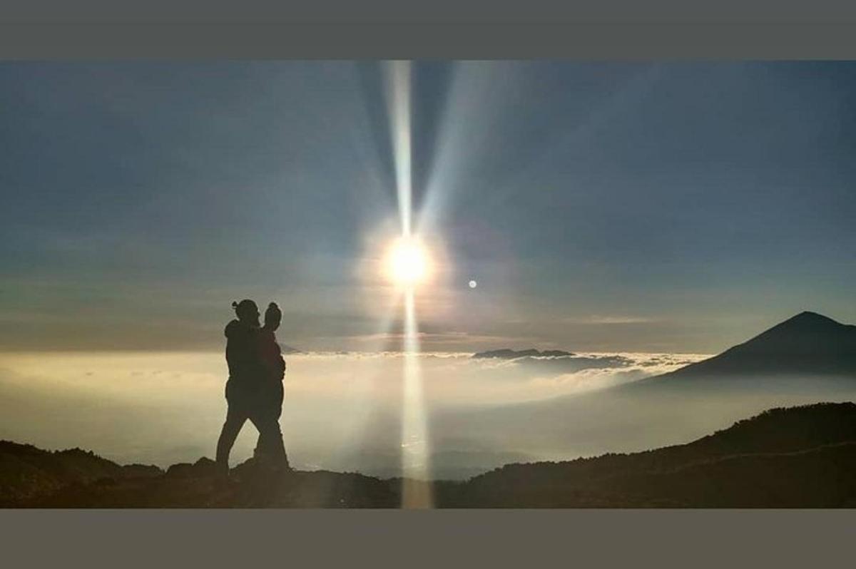 一名男子站在山顶上，沐浴阳光