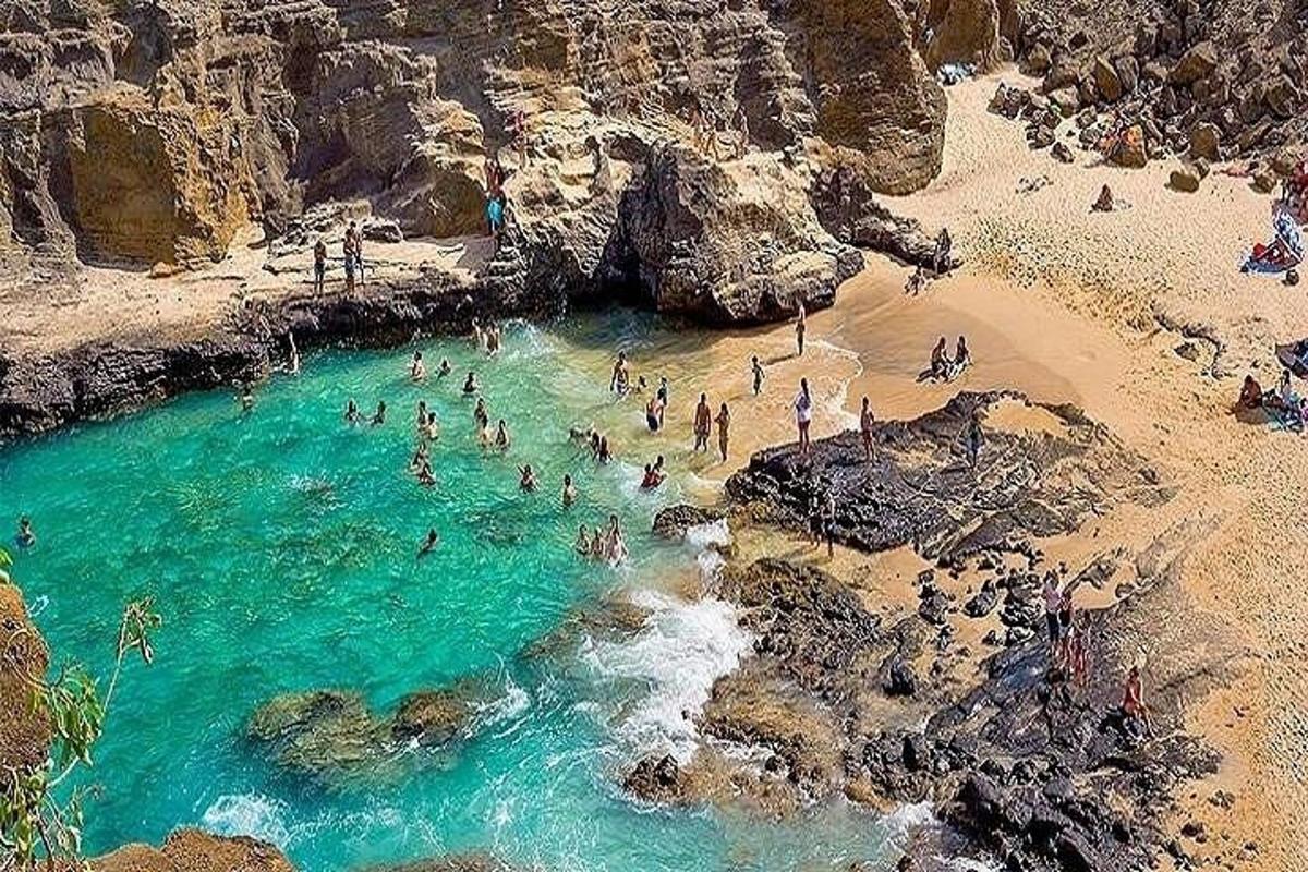 um grupo de pessoas na água em uma praia