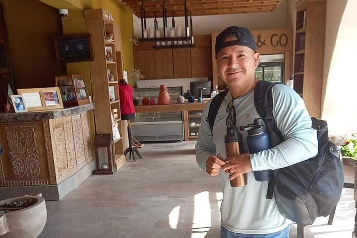 um homem parado em uma cozinha segurando uma câmera
