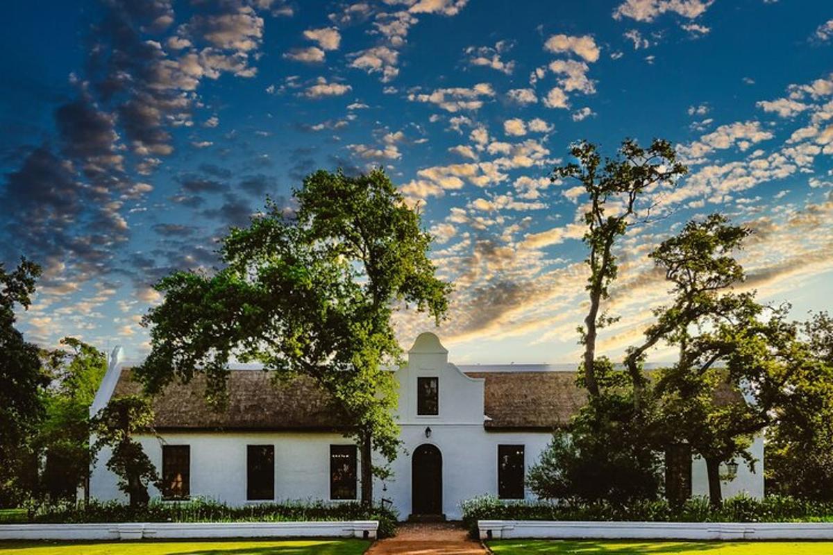 uma casa branca com um céu com nuvens