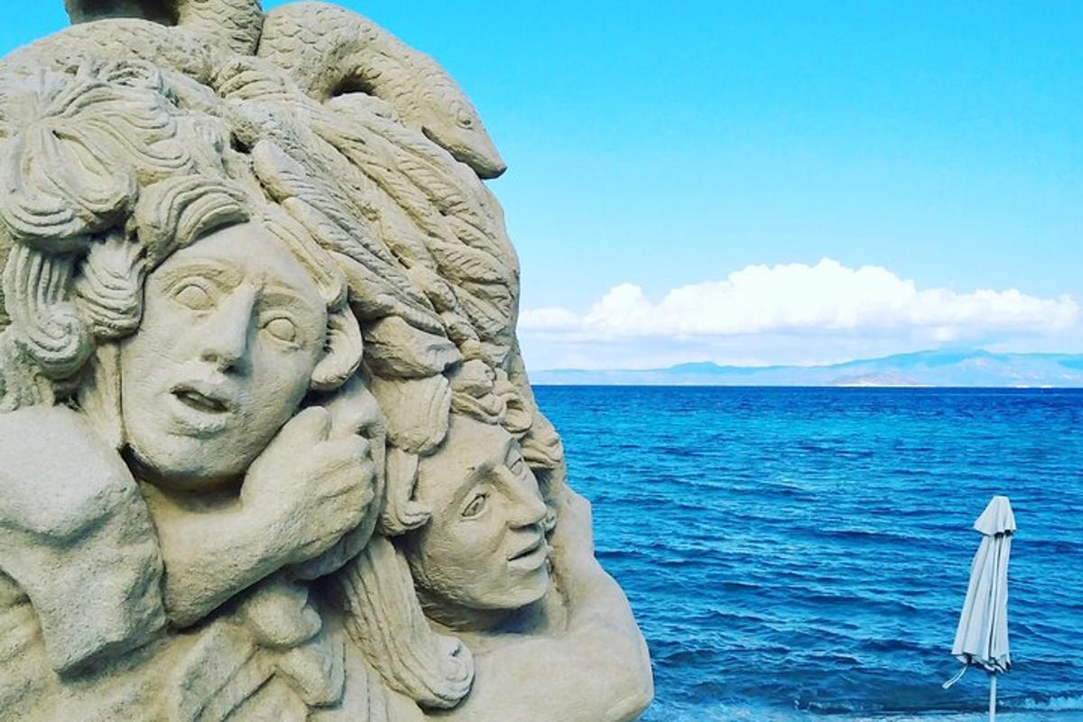 o statuie cu capete cu o umbrelă și oceanul