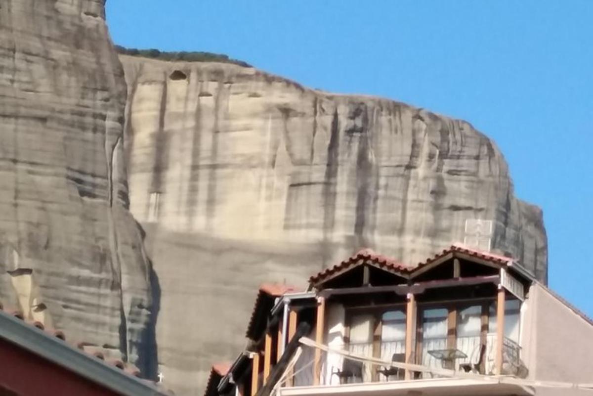 ένα κτίριο μπροστά από έναν μεγάλο πέτρινο τοίχο