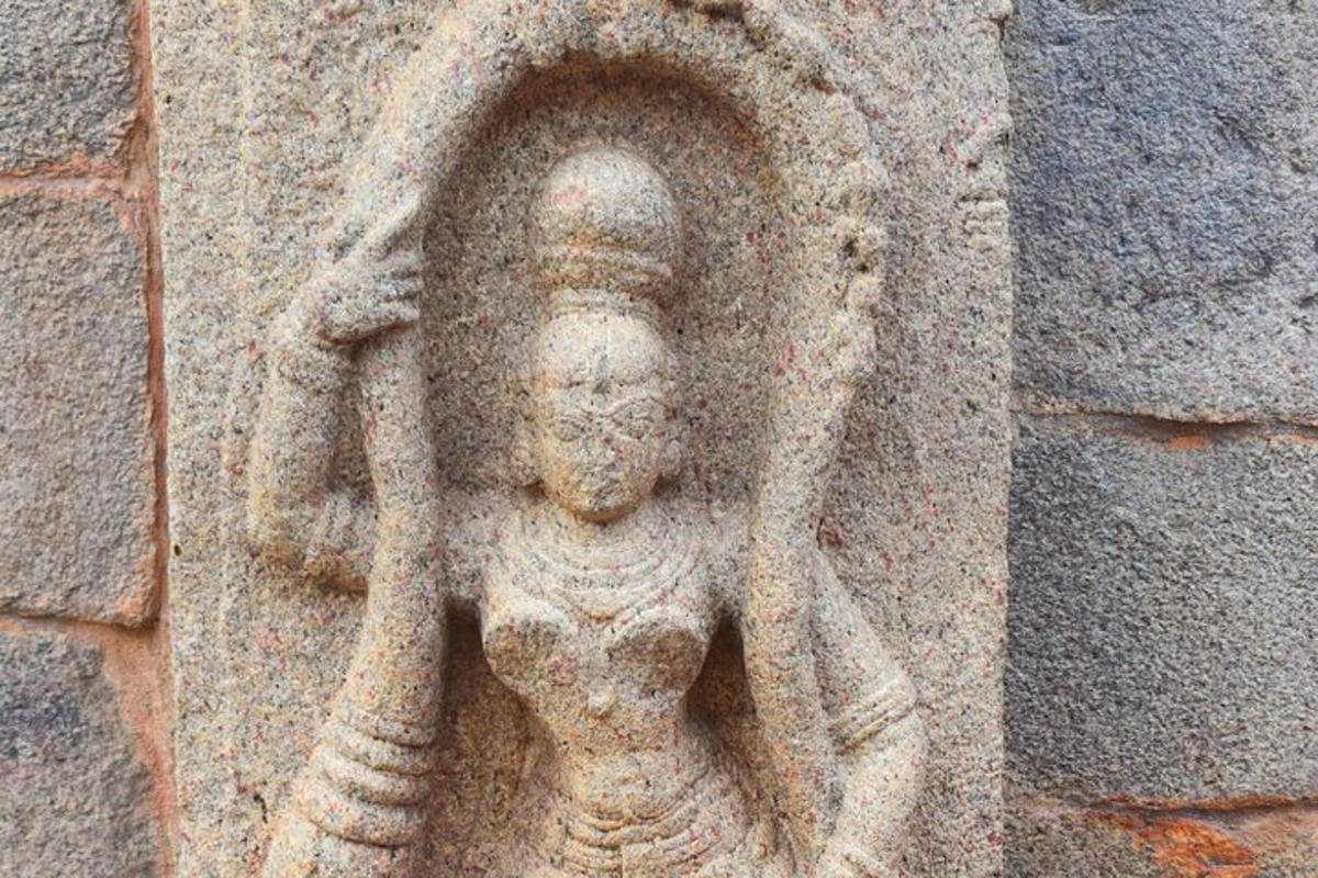 a stone statue of a woman on a wall