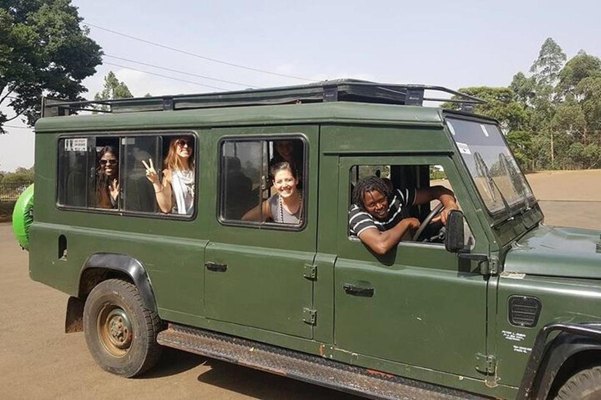 eine Gruppe von Menschen sitzt in einem grünen Jeep