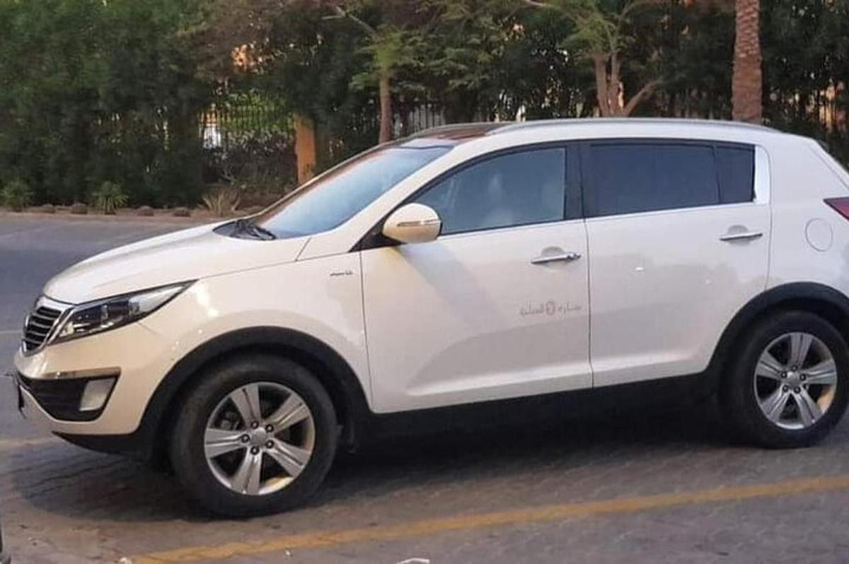 en hvit SUV parkert på en parkeringsplass