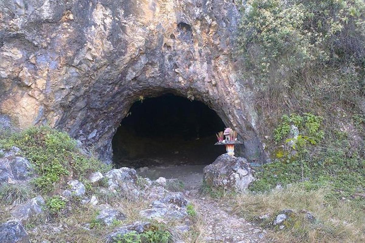 a person sitting on a rock in front of a tunnel