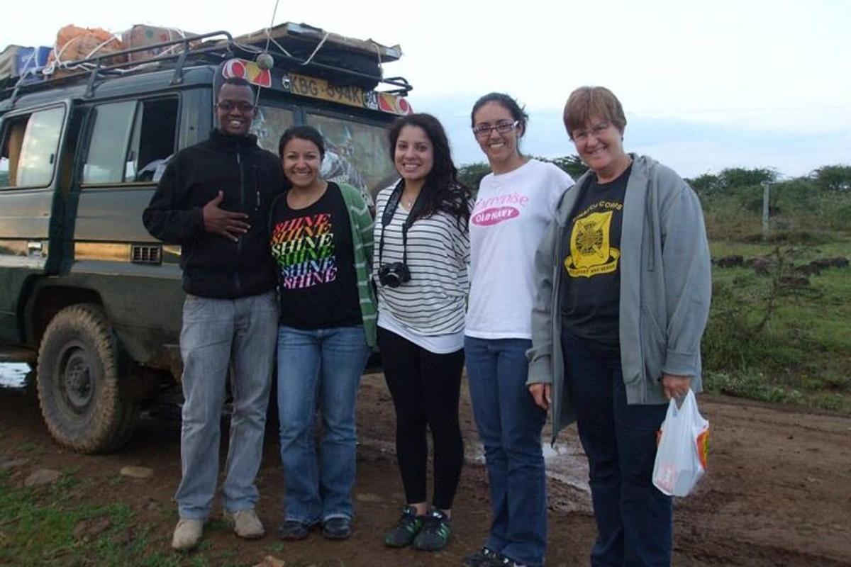 un grupo de personas de pie delante de un vehículo