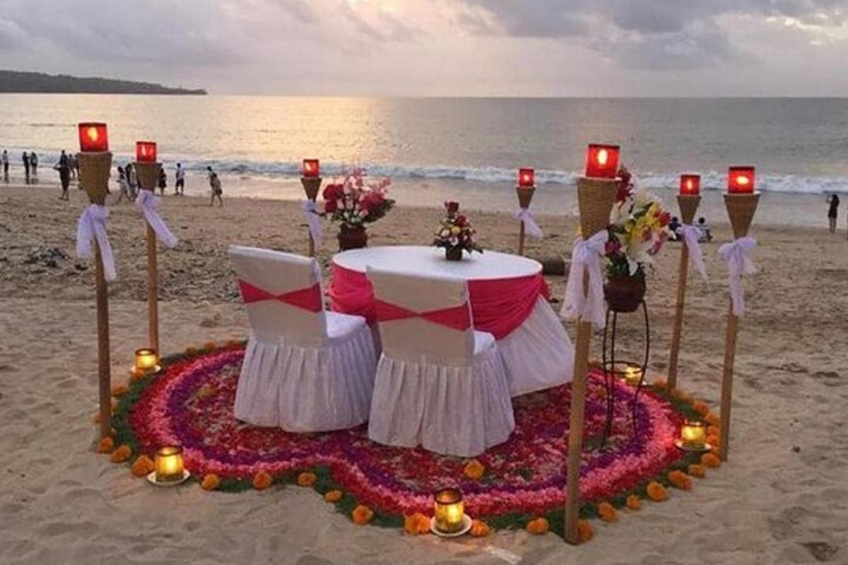 uma mesa na praia com velas e flores