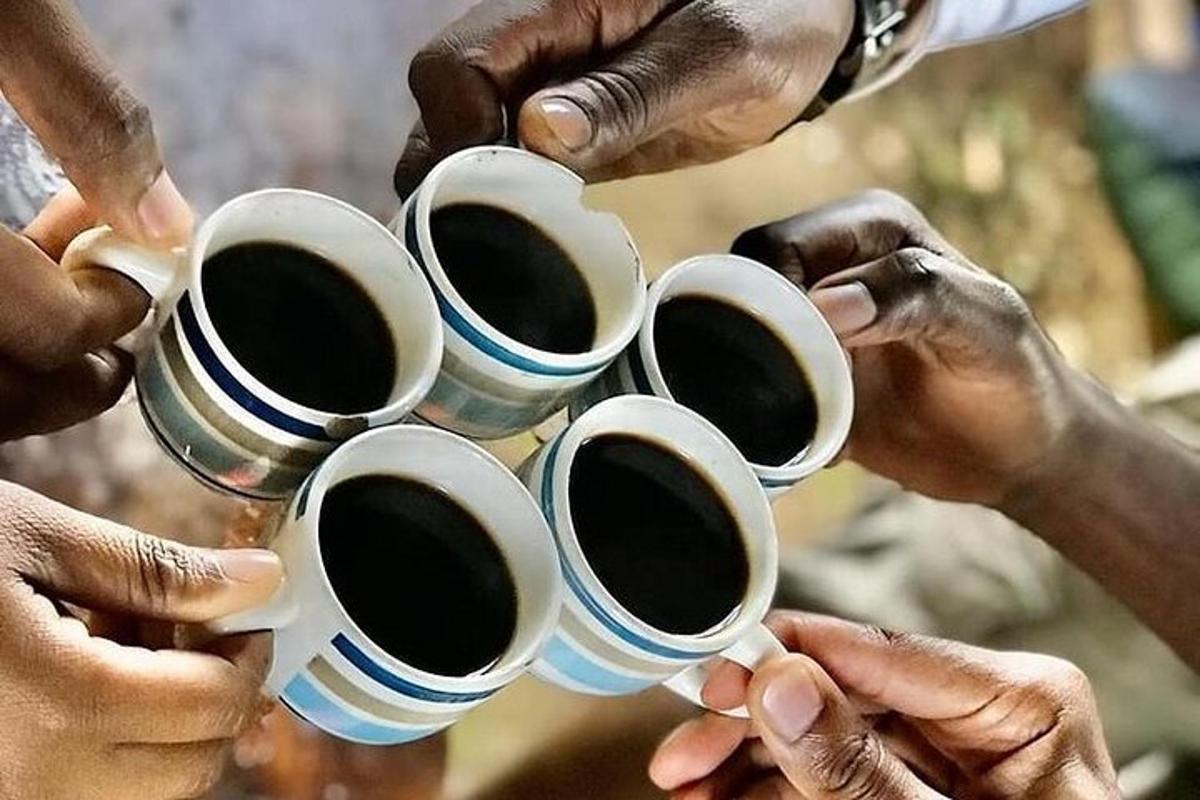 een groep mensen die koffiekopjes omhoog houden