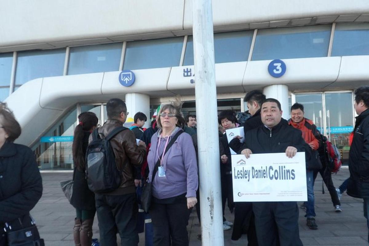 a group of people standing in front of a building holding a sign