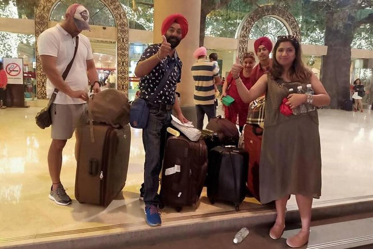 Un grupo de personas de pie en un aeropuerto con equipaje.
