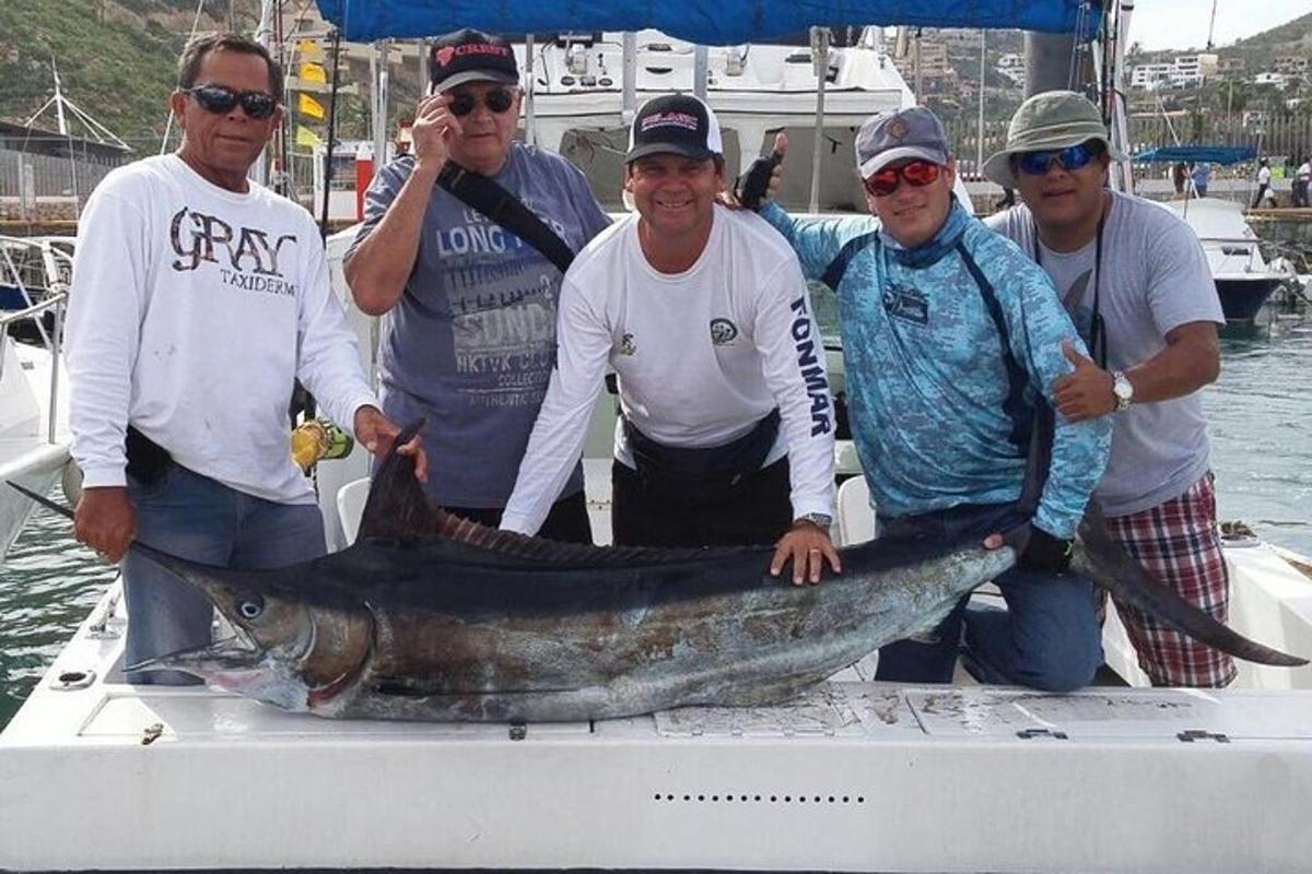 un gruppo di uomini su una barca con un grosso pesce