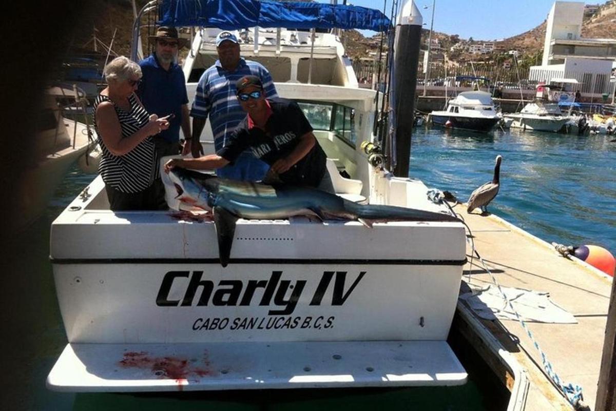 un gruppo di persone su una barca con un pesce