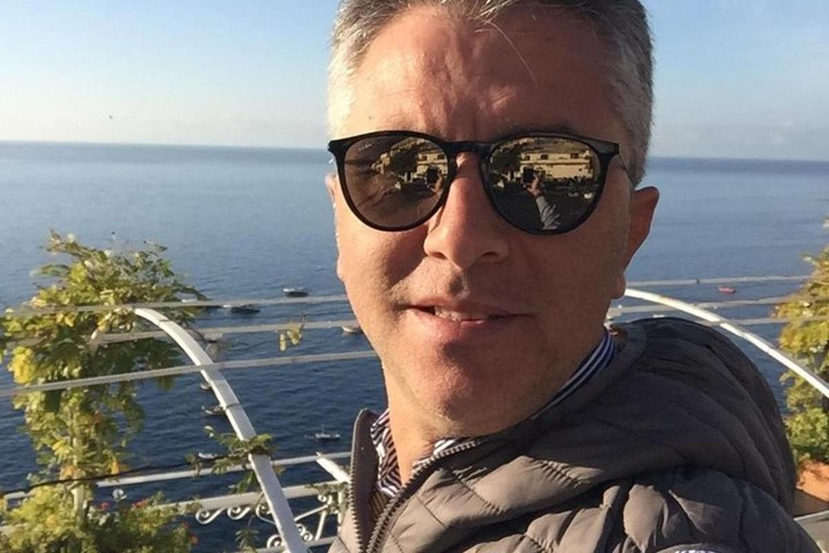 Ένας άντρας με γυαλιά ηλίου στέκεται μπροστά στον ωκεανό