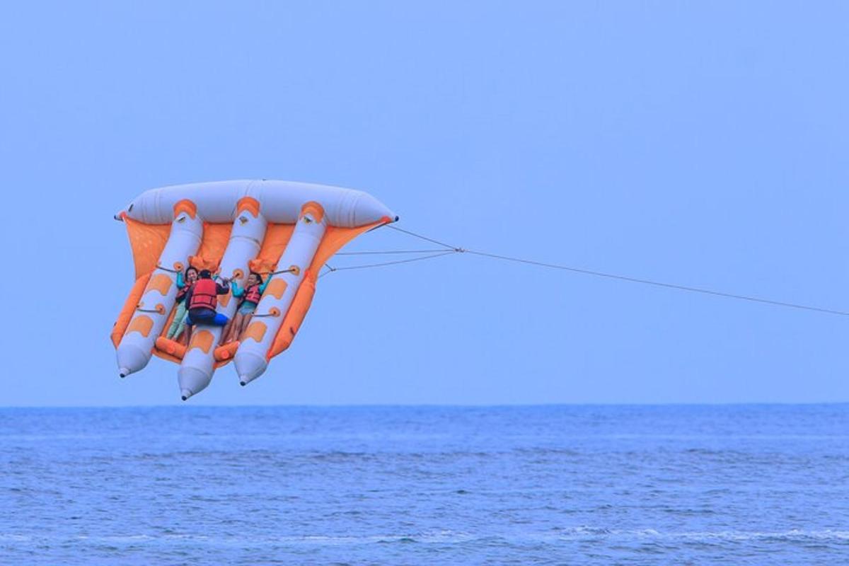 Dos personas viajando en un paracaídas sobre el océano.