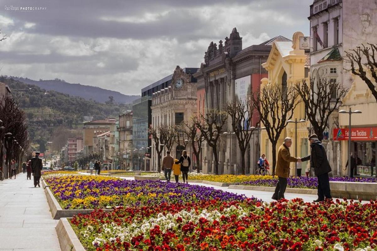 un grup de persones caminant per una ciutat amb flors