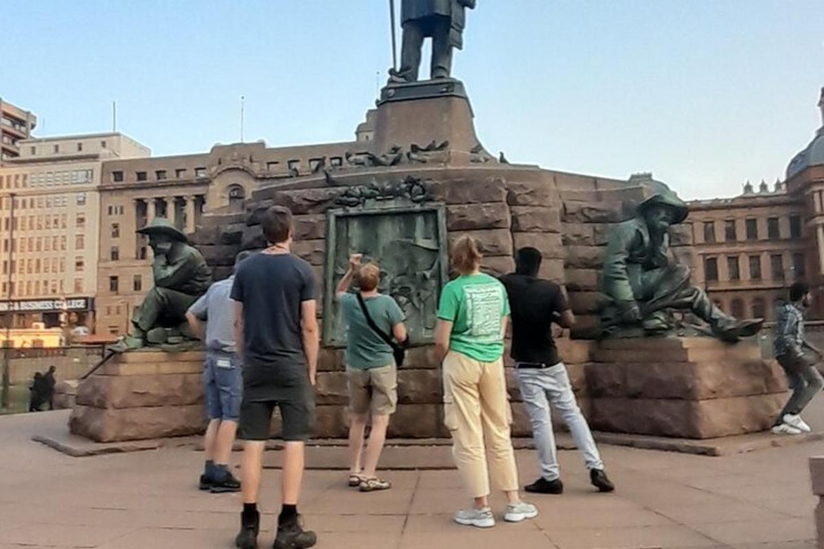 grupp inimesi, kes seisavad kuju ees