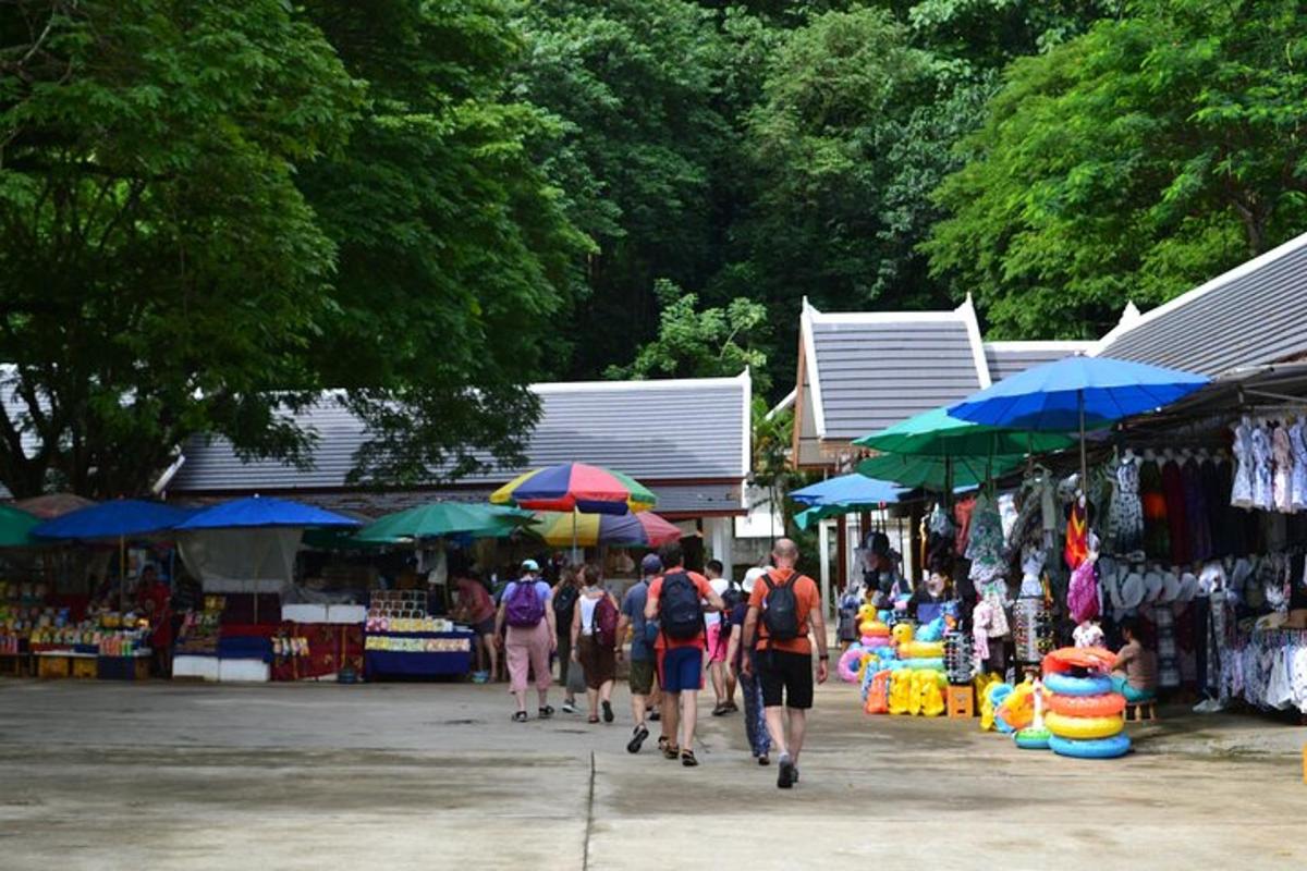a group of people walking through a market with umbrellas