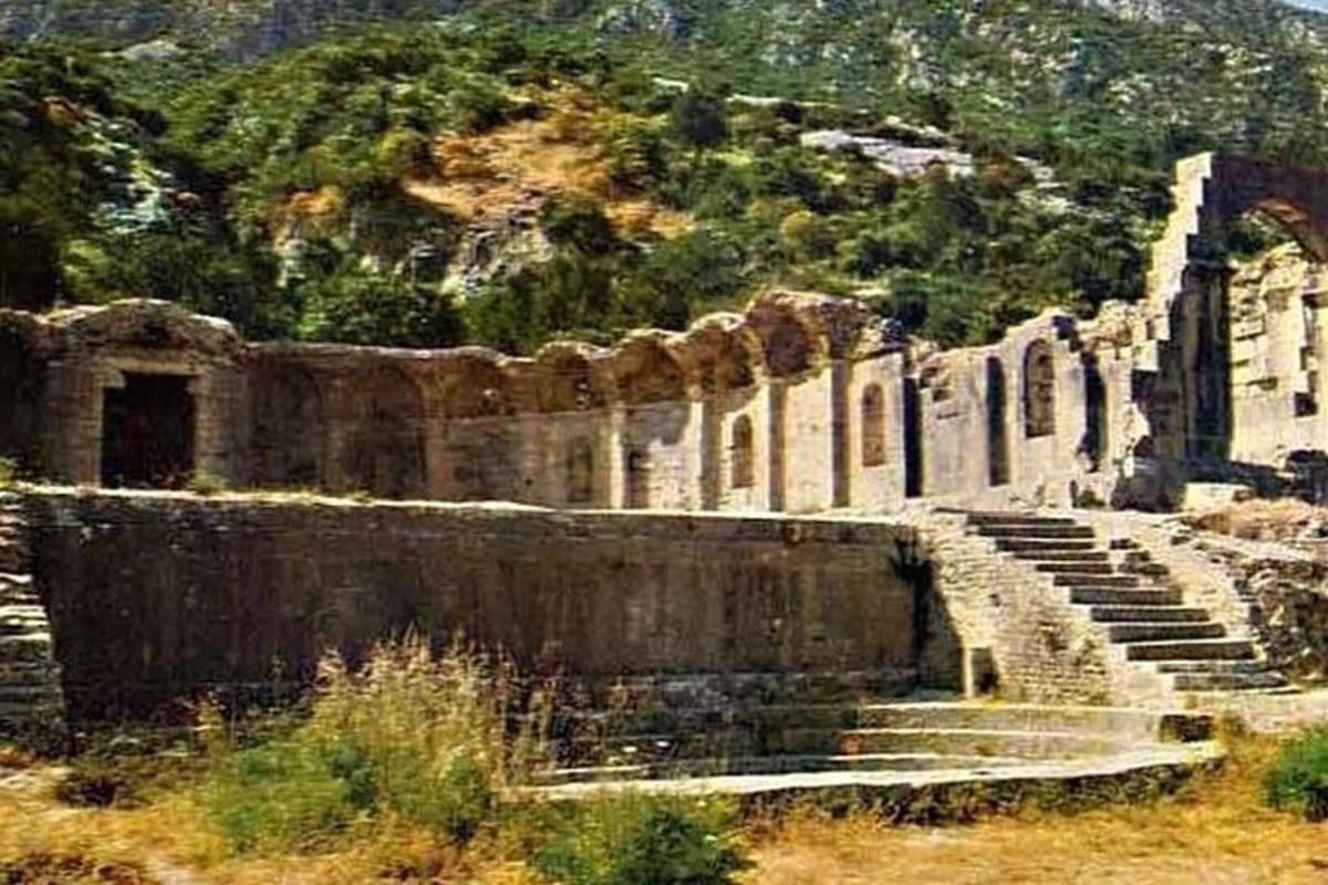 a stone amphitheater with stairs and a mountain