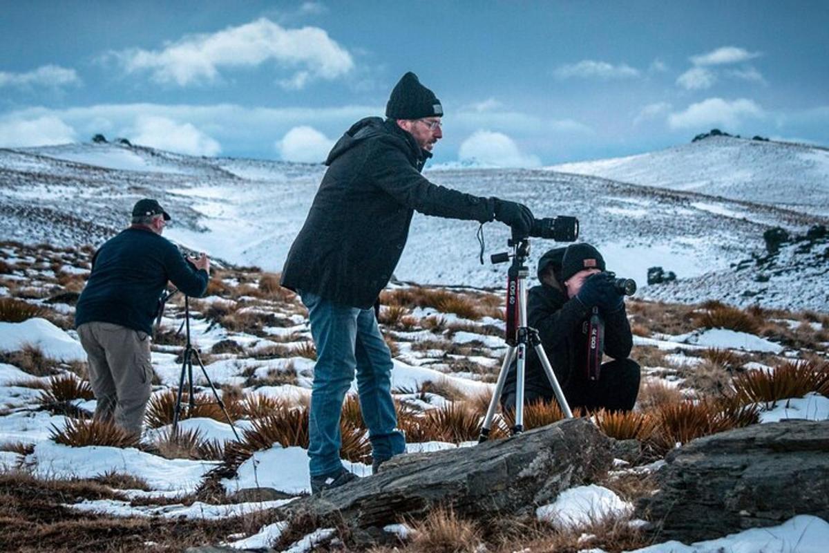 two men and a man with a camera in a snow covered field