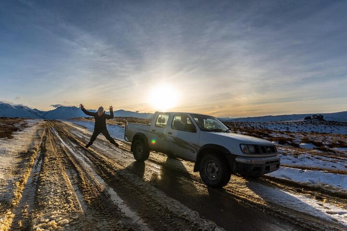 a man standing next to a truck on a dirt road